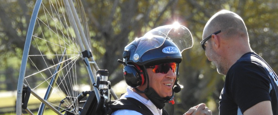 Nicolas accompagne un élève équipé de son paramoteur avant le vol